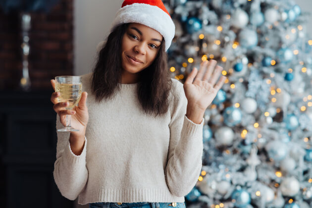 房子在家喝香槟的非裔美国妇女圣诞节庆祝庆祝女人香槟