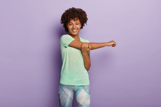 满意快乐的美国黑人运动女性的水平镜头在锻炼前伸展双手 开心地微笑 穿着运动服 身体灵活健康瑜伽紫罗兰