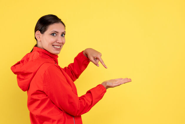 黄正面图黄色背景上穿着红色外套的年轻女性视角情感运动员