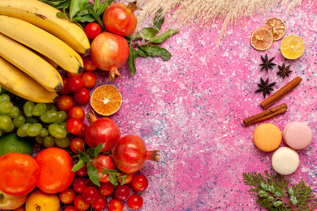 法国顶视图新鲜水果组成与法国马卡龙在浅粉红色的表面成分醇香樱桃番茄