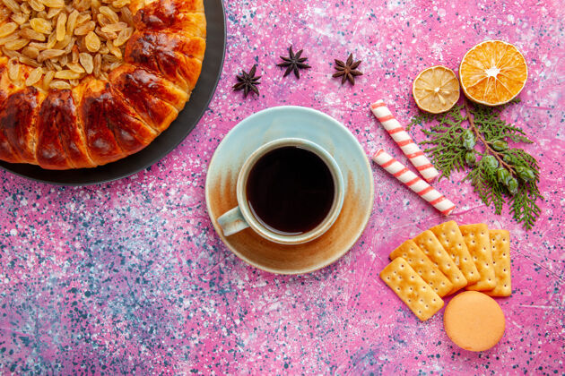 饮料在粉红色的桌子上俯瞰美味的葡萄干 茶和饼干糕点饮料葡萄干热的
