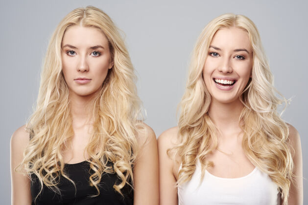 姐妹快乐和悲伤的双胞胎人脸做脸双胞胎