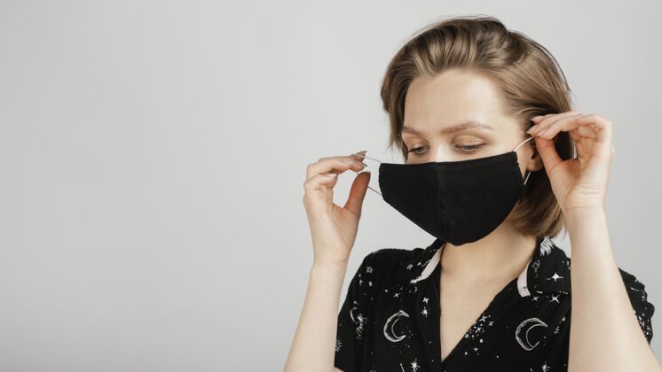 预防戴着黑衬衫和面具的女人措施模特冠状病毒
