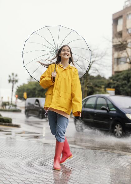 女性带伞的女人站在雨中的正前方表情长相美女