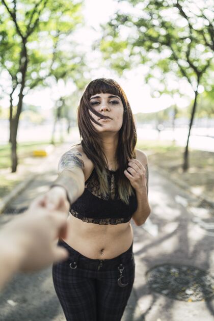 健康年轻漂亮的白种女人站在公园里纹身纹身女性手
