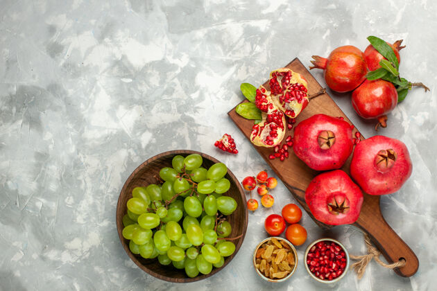 醇香顶视图新鲜的红色石榴酸和醇厚的水果与新鲜的绿色葡萄在淡白色的桌子上健康桌子新鲜