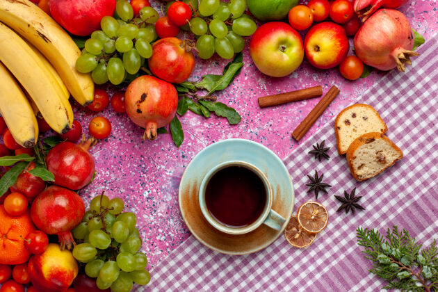 杯子顶视图新鲜水果组成五颜六色的水果与一杯茶在淡粉色的办公桌上茶可食用水果水果