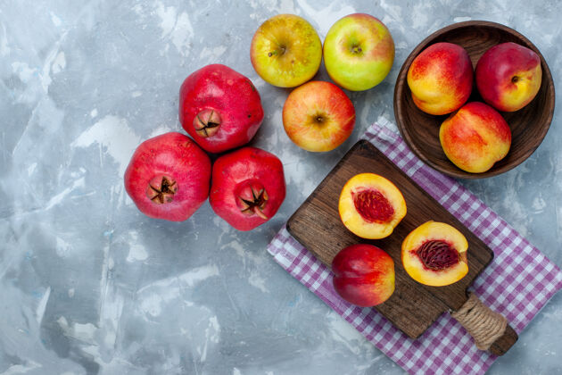 新鲜顶视图新鲜的桃子醇厚可口的水果和苹果放在浅白的桌子上饮食健康水果