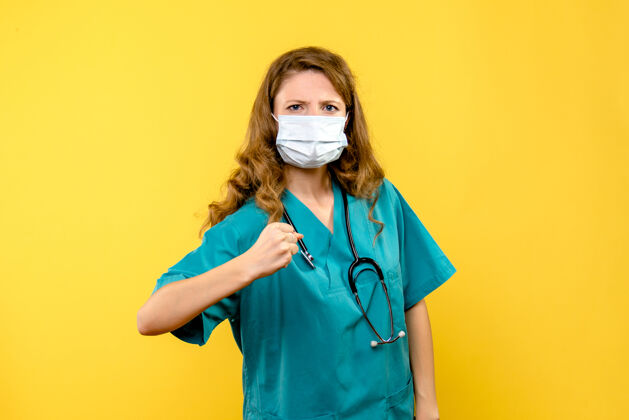实验室外套黄色空间里戴着面具的年轻女医生的正面图面罩医院年轻女医生