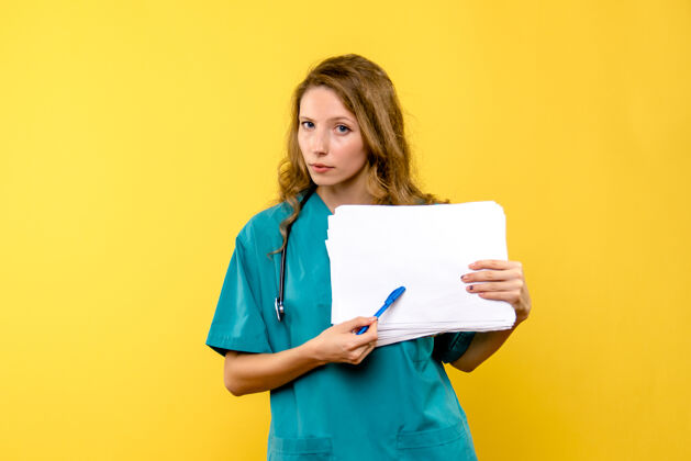 医院正面图黄色空间里的女医生拿着文件情绪人举行
