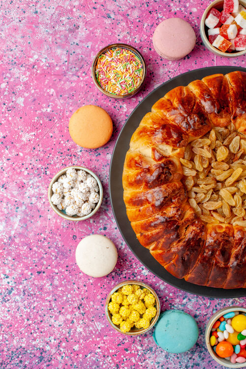 桌子顶视图五颜六色的法国马卡龙小美味蛋糕与糖果和葡萄干馅饼粉红桌糖烤饼干饼干蛋糕馅饼食物五颜六色饼干