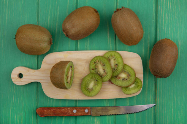 水果顶视图猕猴桃与切片的砧板和刀子上的绿色背景新鲜顶部猕猴桃