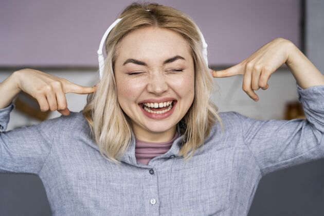 庆祝戴着耳机笑着听音乐的女人的画像乐观国际快乐