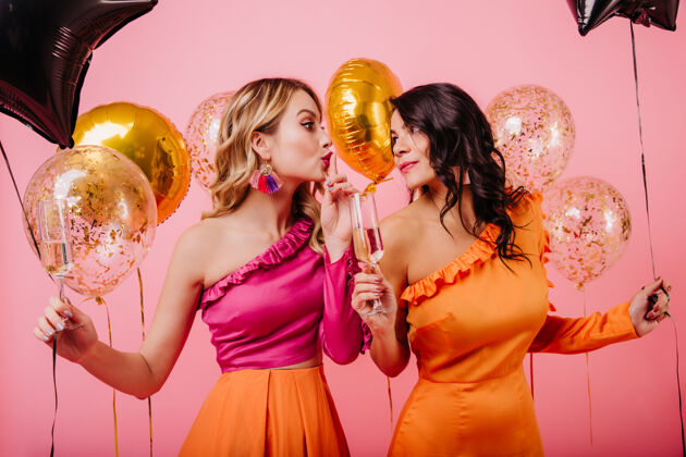 朋友两个拿着闪闪发光的气球的女人在聚会上聊天休闲乐趣模特