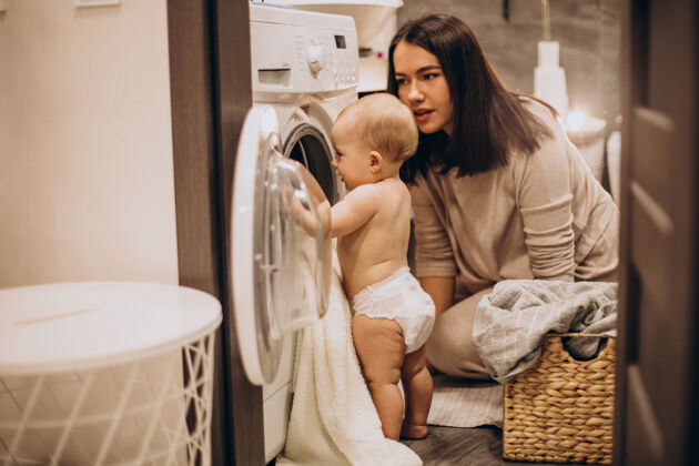 女婴妈妈带着小女儿在家洗衣服快乐女人幼儿