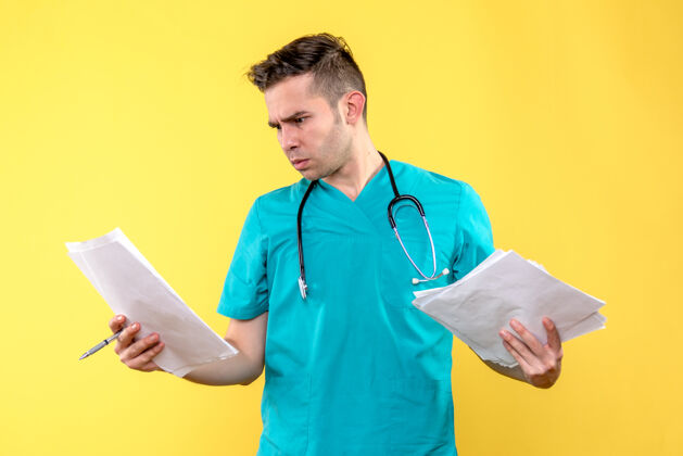 医学黄色墙上有文件的男医生的正视图听诊器人医生