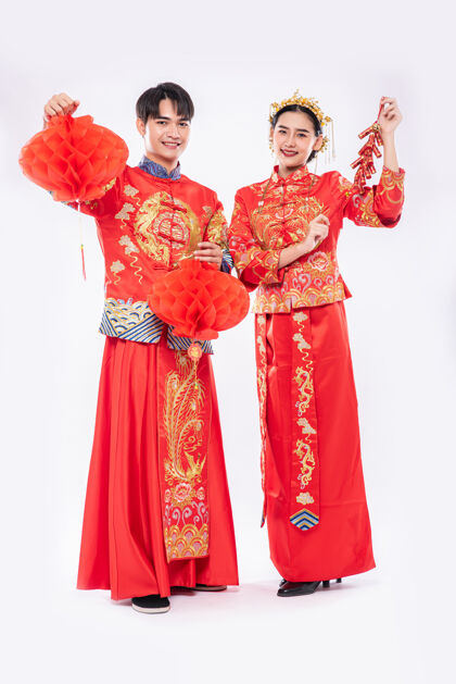欢呼男男女女穿旗袍西服 用红灯笼和鞭炮庆祝中国新年庆祝传统节日成人