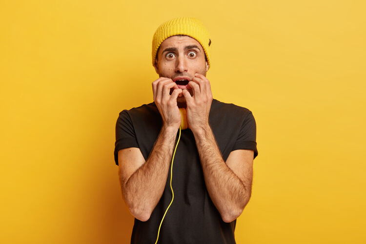 感觉担心害怕的家伙紧张地看着镜头 惊慌失措地咬着指甲麻烦T恤男