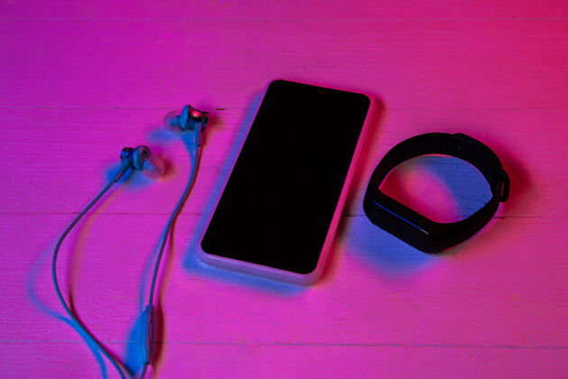 显示紫色霓虹灯和粉色背景的一组小工具的俯视图智能手机和智能手表 耳机广告的复制空间科技 现代 小工具明亮小工具软
