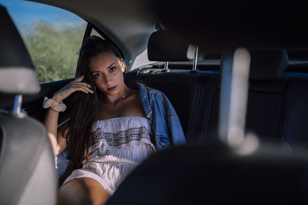 女性一个美丽的年轻白人女性在一个领域的汽车后座摆姿势的水平镜头水平女孩汽车