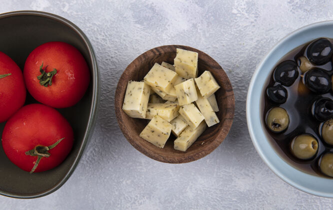 番茄白色背景上有西红柿和橄榄的木制碗上的奶酪俯视图午餐木头金色