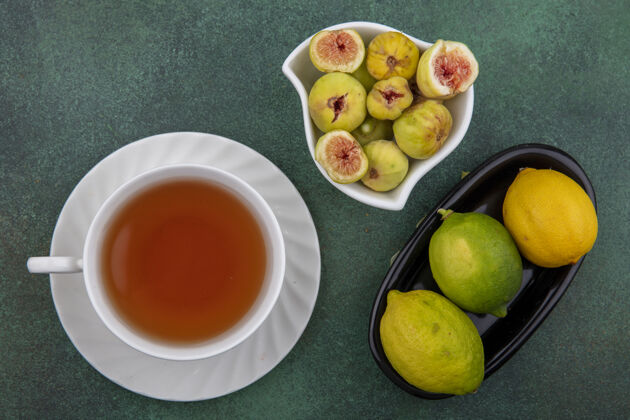 绿茶一杯无花果 酸橙和柠檬的茶 背景是绿色的饮料酸橙早晨