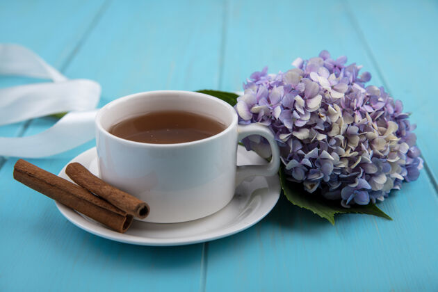 饮料一杯茶的俯视图 肉桂枝上有美丽的栀子花 蓝色木质背景顶杯子风景