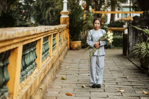 横向在寺庙里手持花束的女人的正面图女人可敬女人