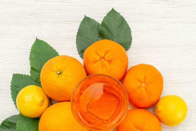 多汁的顶视新鲜橙汁与橙子和柑橘对光白色表面柑橘异国情调的热带果汁异国情调可食用的水果热带
