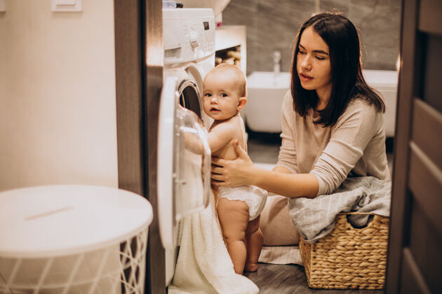 快乐的女人妈妈带着小女儿在家洗衣服女儿童年帮助
