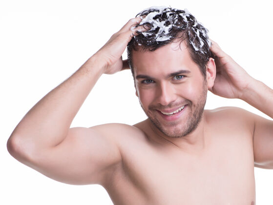 快乐年轻快乐微笑的男人用洗发水洗头-隔离在白色上胡须洗发水男人