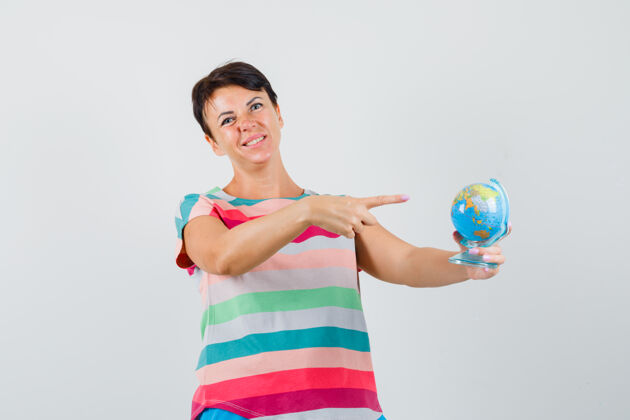 肖像女性穿着条纹t恤指着世界地球仪 看上去很失望前视图护士爆发地球