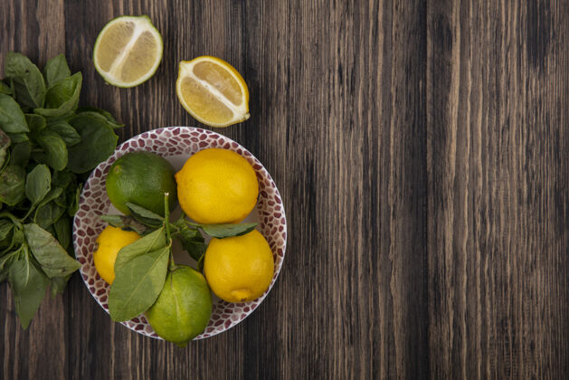 盘子顶视图复制空间柠檬与柠檬在一个楔形和薄荷木背景板上木材新鲜食物