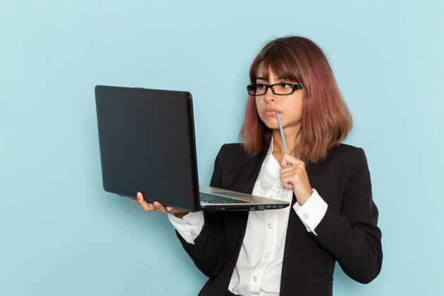 秘书正面图：穿着西装的女上班族在浅蓝色表面上使用笔记本电脑电脑工作工人