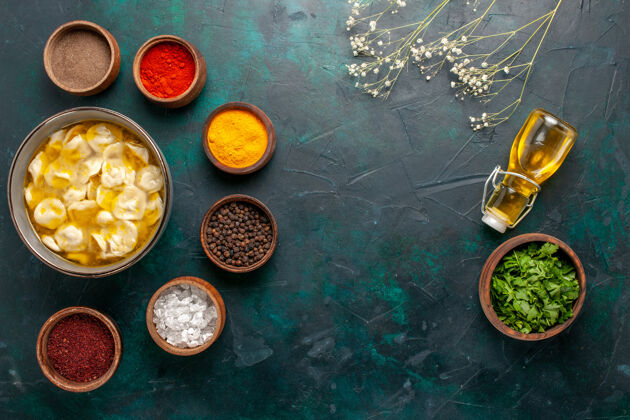 货币顶视图面团汤用不同的调味料和橄榄油在深蓝色的背景上配料汤食物餐面团晚餐酱汤现金视图
