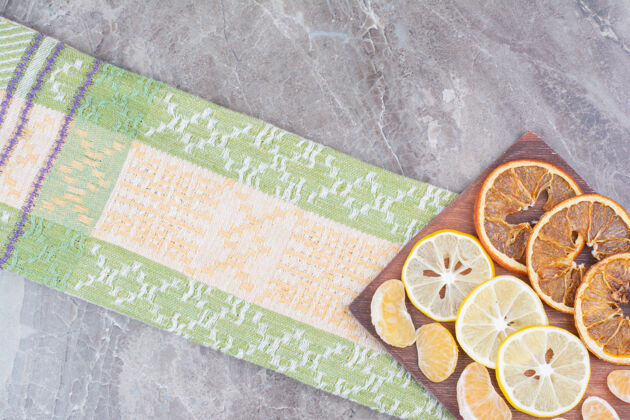 橘子用桌布把柑橘片放在木板上切块干的新鲜