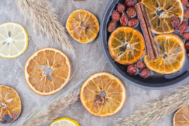 水果干橘子和柠檬片与肉桂在石头表面橙子干的切片