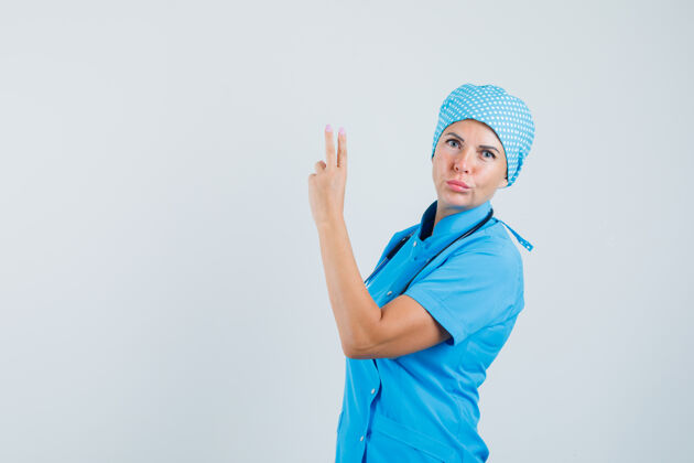 护士穿着蓝色制服的女医生用手和手指做手势 看起来很自信 正面视图预防治疗妇女