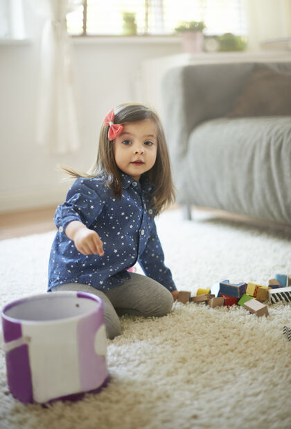沙发游戏结束后 小女孩正在清理积木积木玩具微笑
