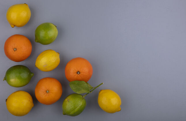 顶部顶视图复制空间橙色与柠檬和灰色背景上的酸橙空间水果酸橙