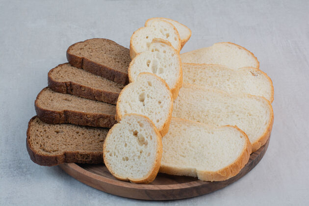 小吃新鲜的白色和棕色面包片放在大理石背景上食品糕点面包片