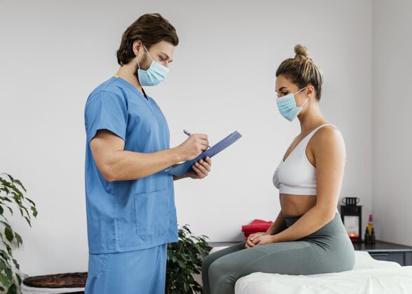 治疗师一边是带着医用面罩的男性骨科治疗师 一边是办公室里的女性患者运动男人女人