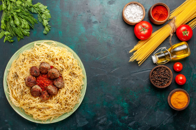 肉丸俯瞰美味的意大利面食与肉丸和番茄酱在深蓝色桌面团面食菜肉食意大利面食酱汁视图