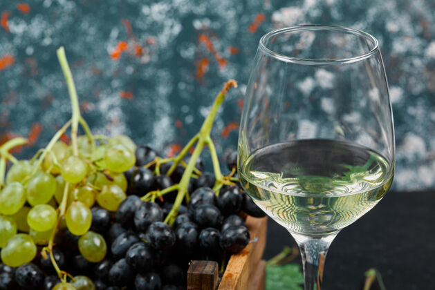 生物一杯白葡萄酒 周围有一束绿葡萄极简主义产品浆果