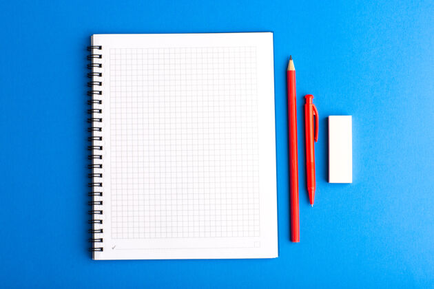 学校前视图打开文案与蓝色表面上的铅笔正面笔记本抄写本