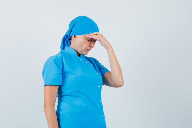 外科医生身着蓝色制服的女医生揉着额头 看上去很疲惫 前视图实验室肖像制服