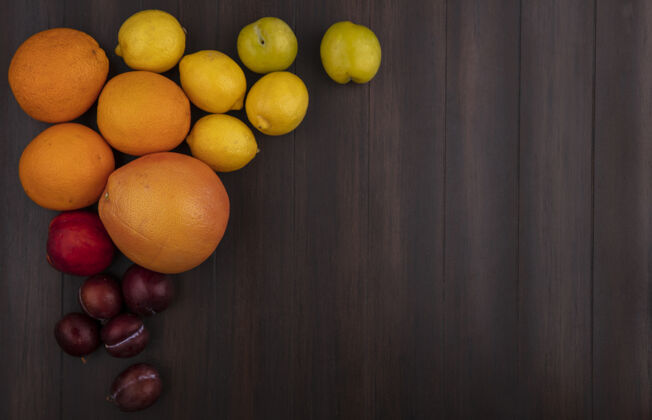 李子顶视图复制空间樱桃李子柠檬橙子葡萄柚和桃子木制背景食物景观葡萄柚