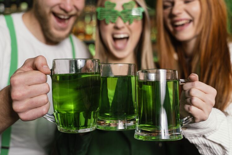 男士一群朋友在酒吧用饮料庆祝圣帕特里克节的前视图酒吧3月17日场合