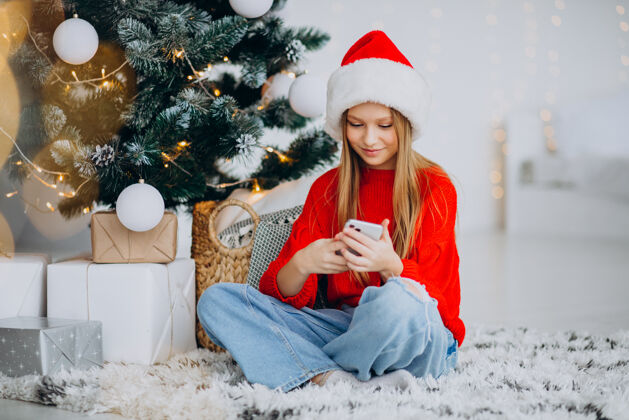 看圣诞节 在圣诞树旁打电话的女孩电话可爱科技