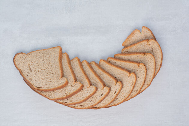 面包大理石背景上的新鲜棕色面包片糕点烘焙面包切片